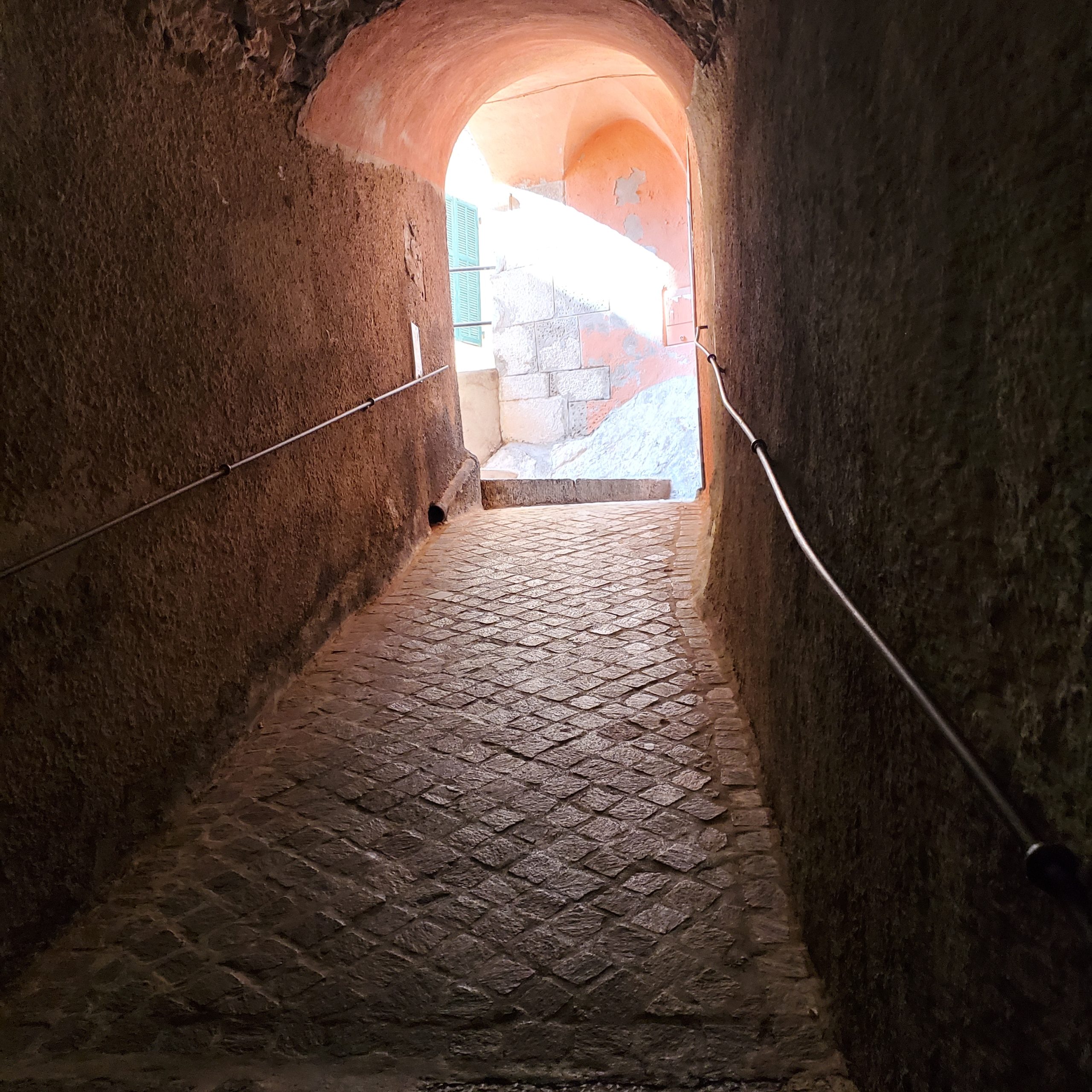 The gorgeous arched tunnel made of stone; a threshold between now and next, gorgeously sun-lit at the end